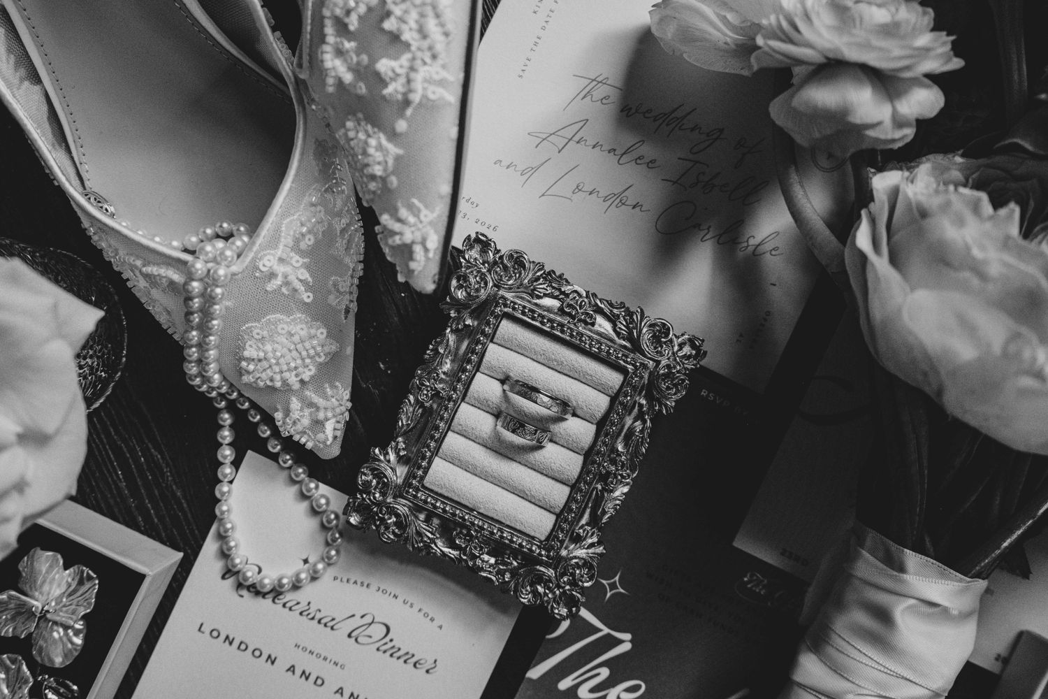 Black-and-white still life of letters, a framed keepsake and flowers